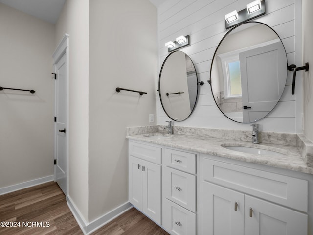 bathroom featuring hardwood / wood-style flooring, vanity, and wood walls