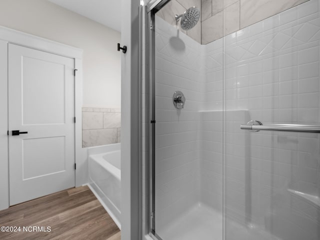 bathroom with shower with separate bathtub and hardwood / wood-style floors