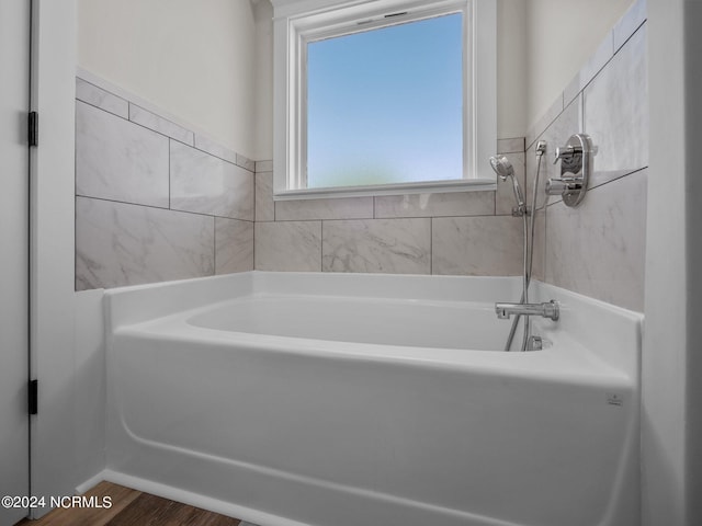 bathroom featuring hardwood / wood-style flooring and a washtub