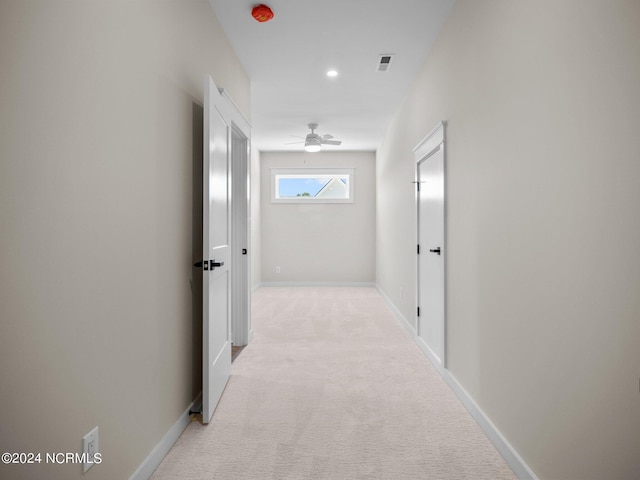 hallway featuring light colored carpet