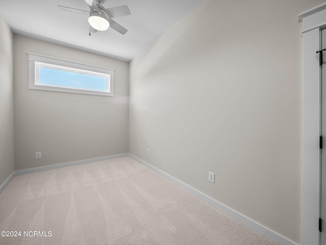 spare room featuring light colored carpet and ceiling fan