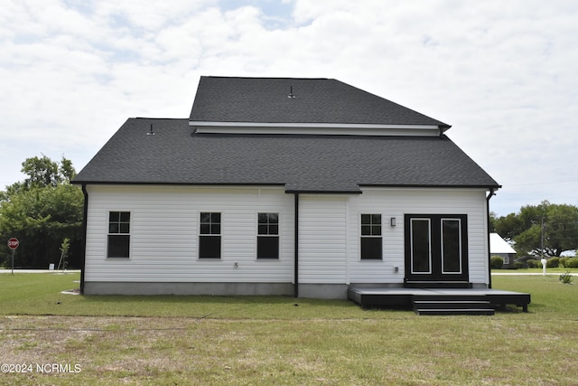 rear view of property featuring a lawn