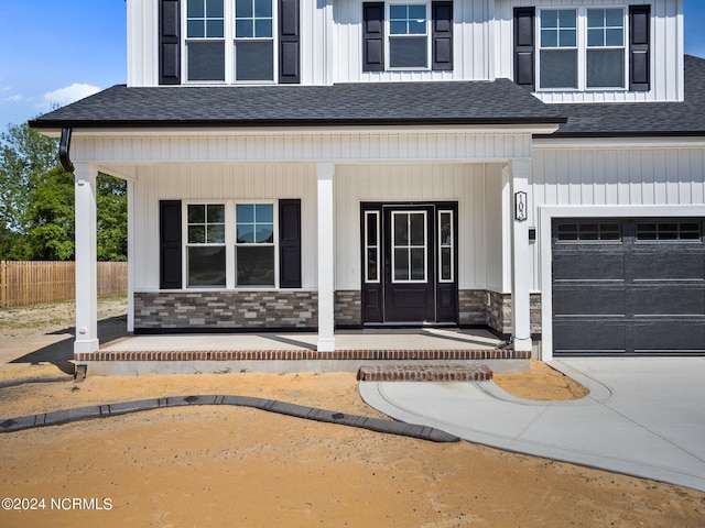 entrance to property featuring a garage and covered porch