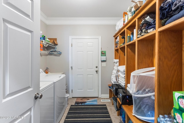 interior space featuring washing machine and clothes dryer, crown molding, and light tile flooring