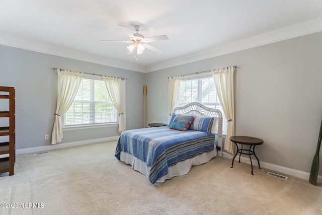 carpeted bedroom featuring crown molding and ceiling fan