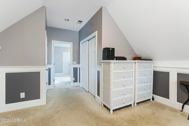 interior space featuring light colored carpet and lofted ceiling