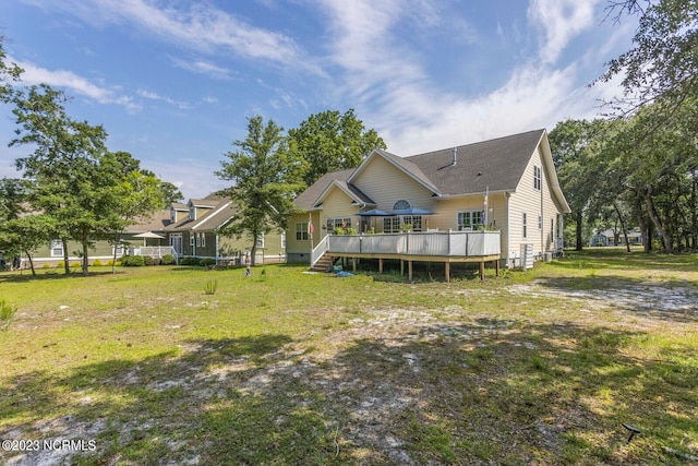 back of property with a lawn and a deck