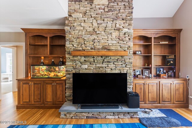 unfurnished living room with a stone fireplace and light wood-type flooring