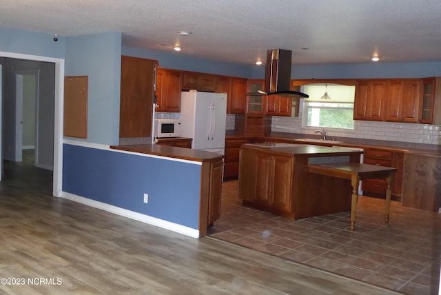 kitchen featuring dark hardwood / wood-style floors, white appliances, sink, range hood, and a center island