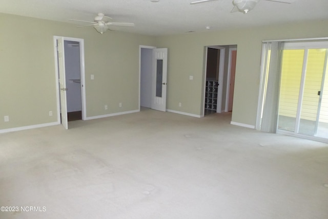 carpeted spare room featuring ceiling fan and a wealth of natural light