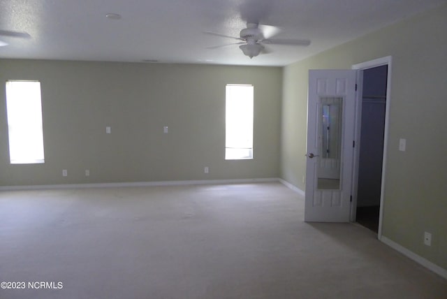 carpeted empty room with ceiling fan and a textured ceiling