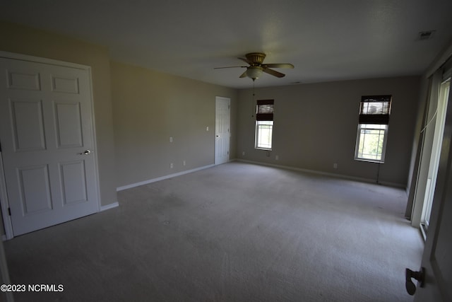 empty room featuring ceiling fan and light carpet