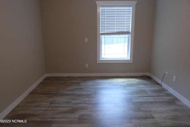 unfurnished room with dark hardwood / wood-style flooring