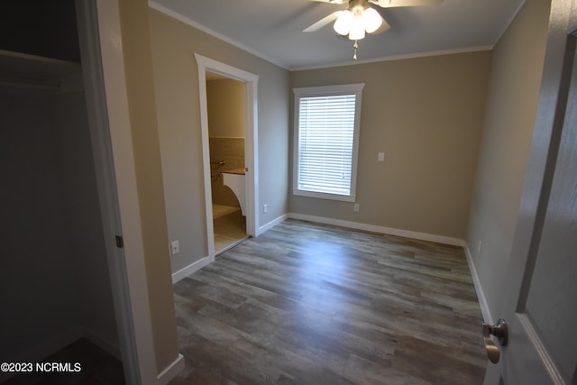 unfurnished bedroom featuring ceiling fan, a closet, connected bathroom, crown molding, and dark hardwood / wood-style floors