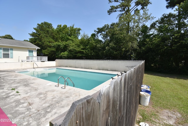 view of swimming pool with a yard