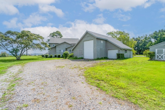 view of front of property with an outdoor structure, a garage, and a front lawn