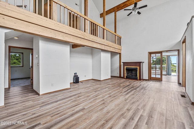 unfurnished living room with high vaulted ceiling and plenty of natural light