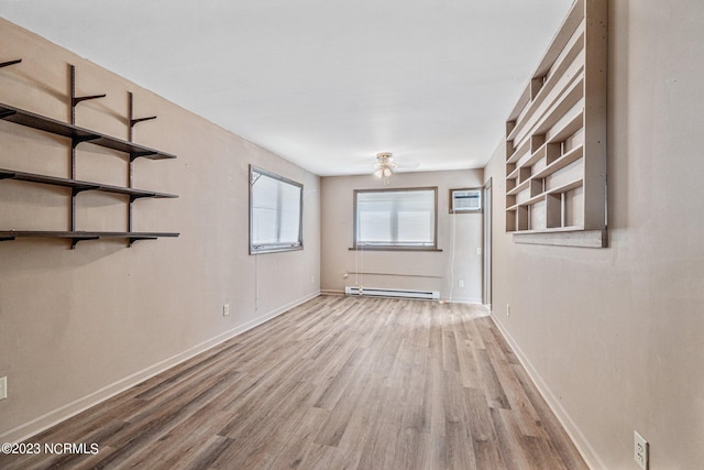 unfurnished room with a baseboard radiator, light hardwood / wood-style flooring, and a wall mounted air conditioner