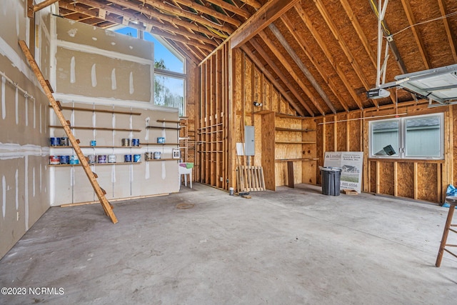 garage with a garage door opener and electric panel