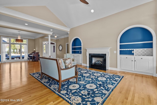 living room featuring ceiling fan, light hardwood / wood-style flooring, high vaulted ceiling, built in features, and ornamental molding