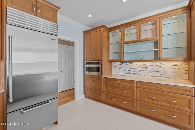 kitchen with appliances with stainless steel finishes, tasteful backsplash, crown molding, and light tile patterned flooring