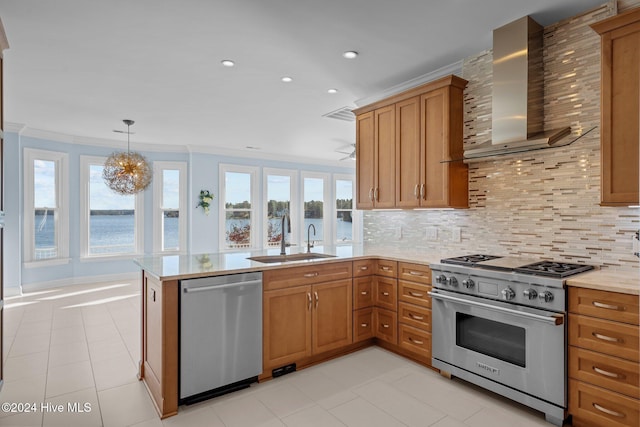 kitchen featuring a wealth of natural light, sink, wall chimney range hood, kitchen peninsula, and appliances with stainless steel finishes