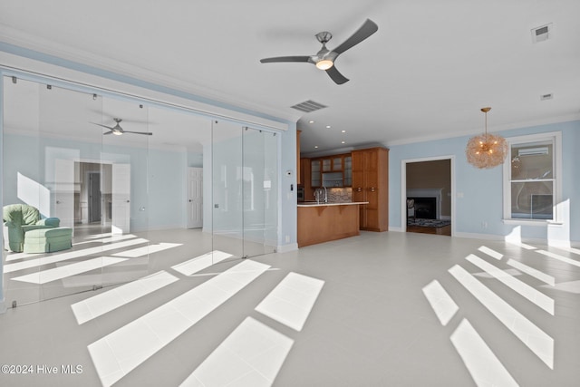 unfurnished living room featuring ceiling fan and ornamental molding