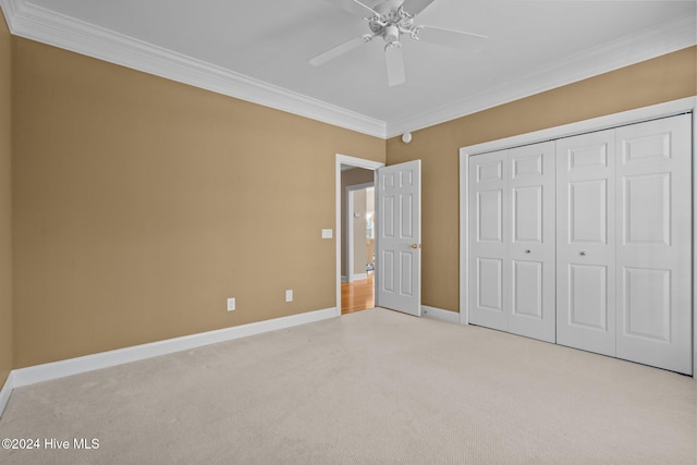 unfurnished bedroom with ceiling fan, ornamental molding, light carpet, and a closet