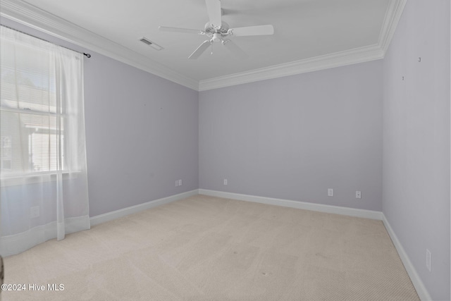 carpeted spare room featuring ceiling fan and crown molding