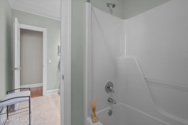 bathroom with crown molding, tile patterned flooring, and  shower combination