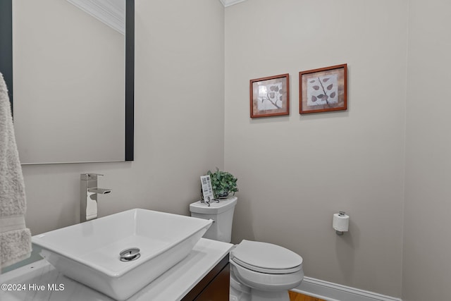 bathroom featuring vanity, toilet, and ornamental molding