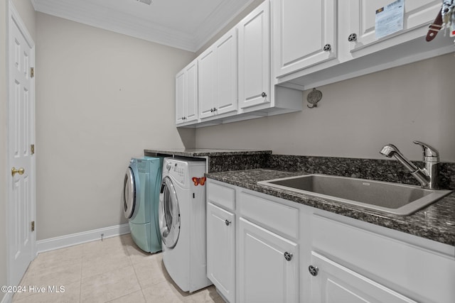 clothes washing area with sink, cabinets, washing machine and dryer, light tile patterned floors, and ornamental molding