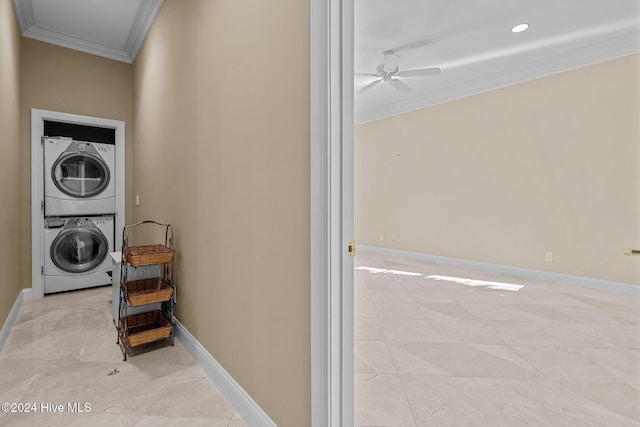 washroom featuring ceiling fan, stacked washer and dryer, and ornamental molding