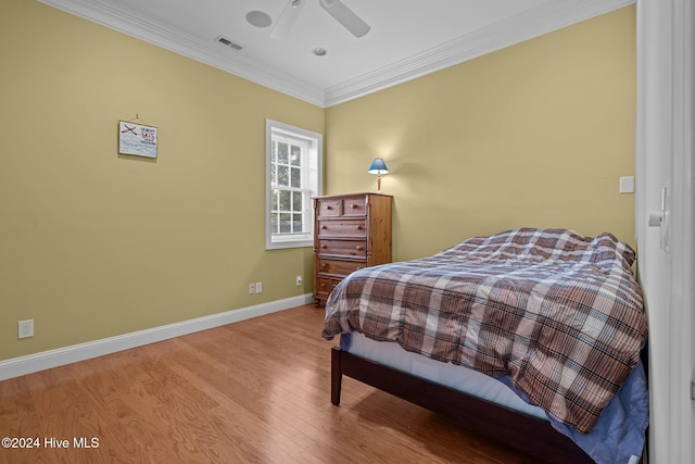 bedroom with hardwood / wood-style floors, ceiling fan, and crown molding