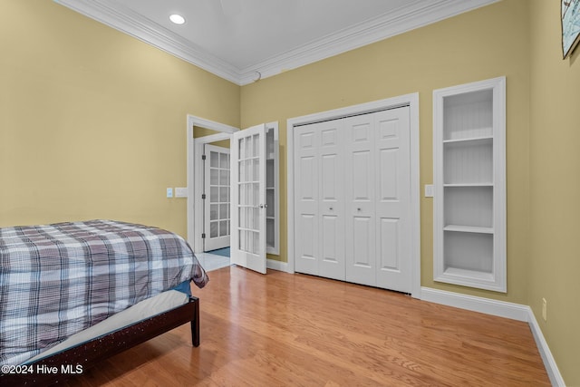 bedroom with crown molding, a closet, and light wood-type flooring