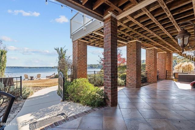 view of patio / terrace featuring a water view and a balcony