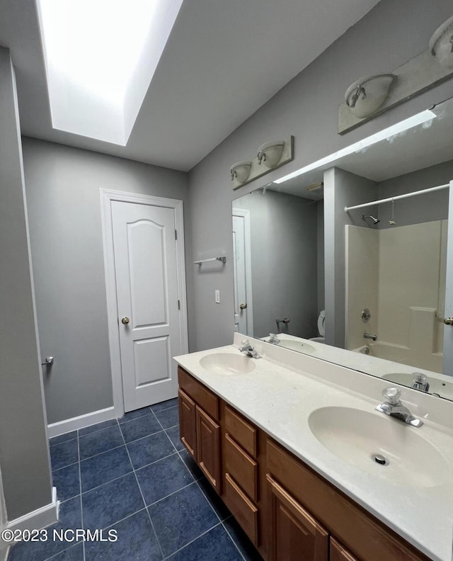 full bathroom with toilet, large vanity, tub / shower combination, dual sinks, and tile floors