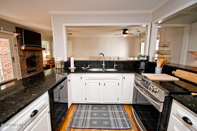 kitchen featuring stainless steel range with electric cooktop, ceiling fan, dark hardwood / wood-style flooring, and a brick fireplace