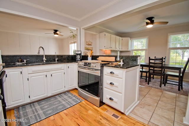 kitchen featuring white cabinets, ceiling fan, stainless steel range with electric cooktop, and light tile floors