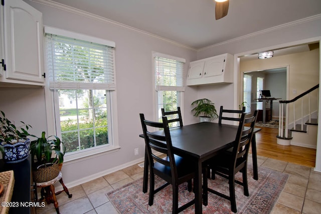 tiled dining space with ceiling fan, ornamental molding, and a wealth of natural light