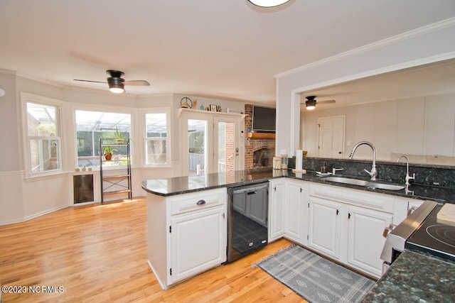 kitchen featuring ceiling fan, sink, kitchen peninsula, and light hardwood / wood-style floors