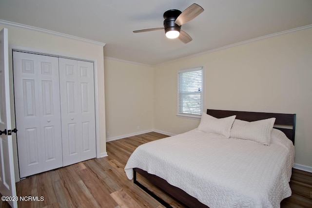 bedroom featuring ceiling fan, crown molding, light hardwood / wood-style floors, and a closet