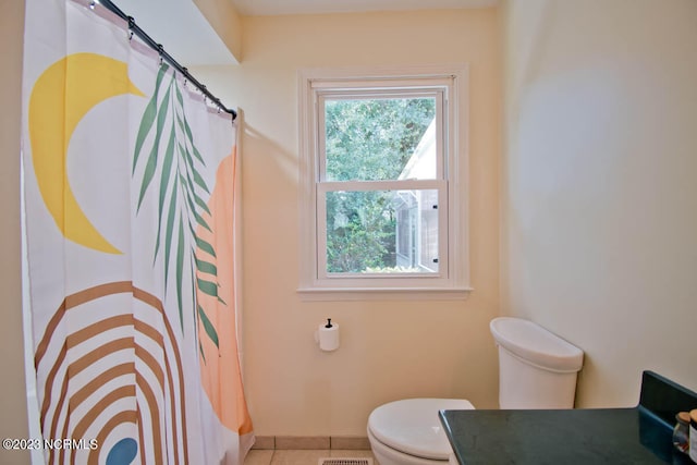 bathroom with tile flooring, toilet, and vanity