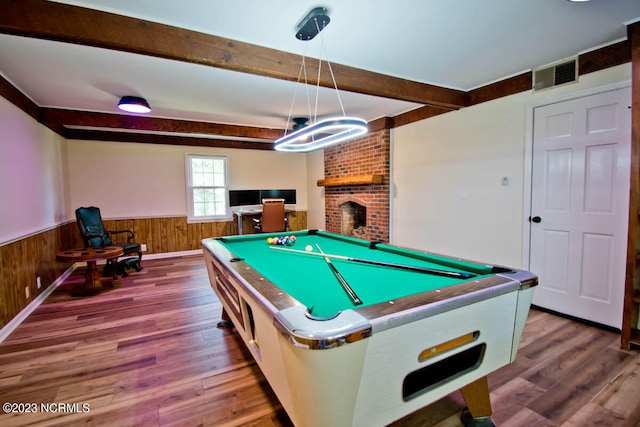 recreation room with brick wall, hardwood / wood-style floors, pool table, a fireplace, and beam ceiling