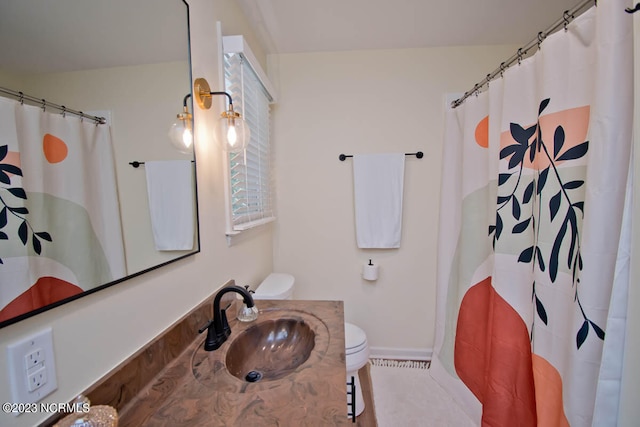 bathroom featuring toilet, tile flooring, and sink