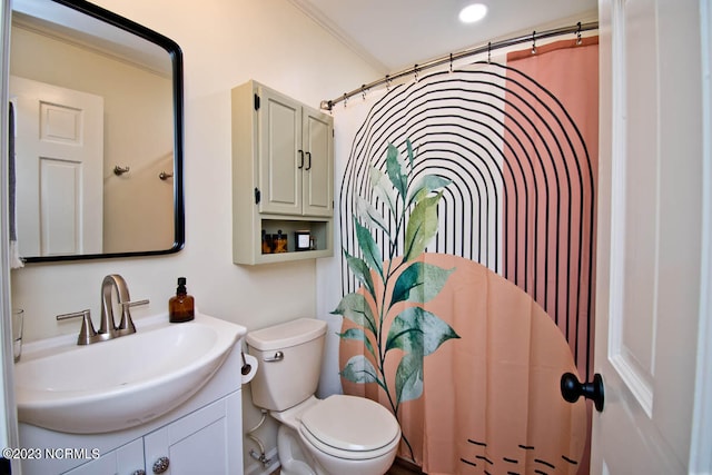 bathroom with vanity, toilet, and ornamental molding