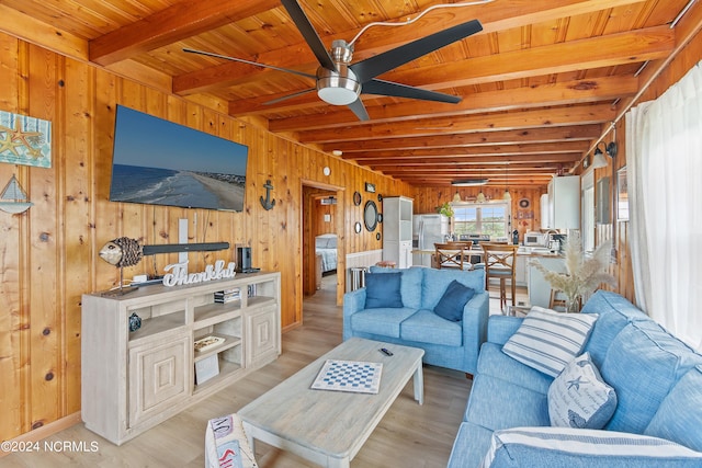 living room featuring ceiling fan, beamed ceiling, wood walls, light hardwood / wood-style floors, and wood ceiling