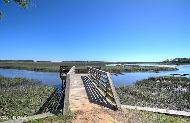 dock area with a water view and a beach view