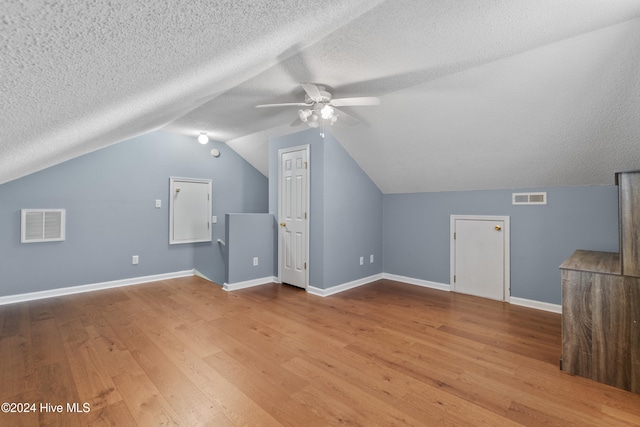 bonus room featuring wood-type flooring, a textured ceiling, ceiling fan, and lofted ceiling