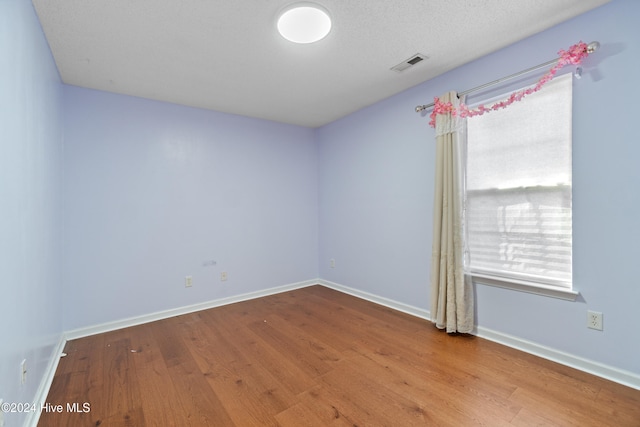 empty room featuring hardwood / wood-style floors and a textured ceiling